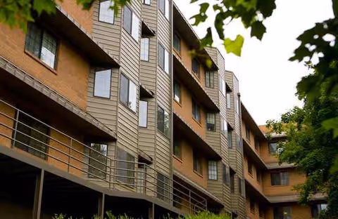 Exterior view of a multi-story senior living building with balconies.