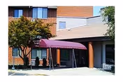 Exterior view of Yellowwood Terrace entrance with maroon awning and surrounding trees.