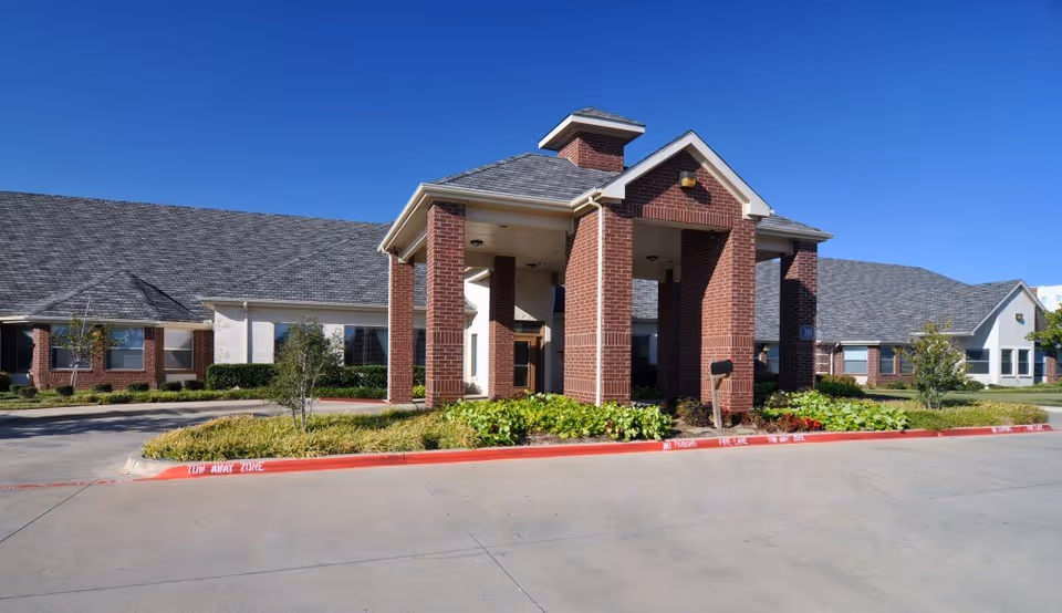Brick Mansfield Medical Lodge exterior with a covered entrance and landscaped front yard.