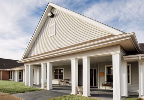 Exterior view of Meredith Court senior living facility with a gabled roof and columns.