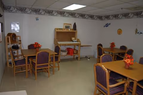 A dining room with wooden tables, purple chairs, and flower centerpieces.