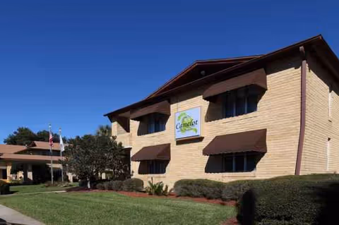 Two-story brick building with Camelot Chateau sign, awnings, and a well-kept front lawn.