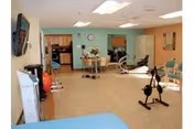 Interior exercise/activity room with stationary bikes, chairs, a treatment table, and a kitchenette area.