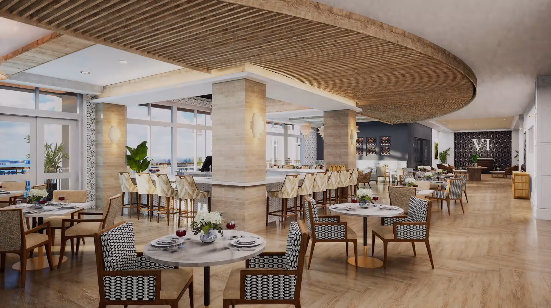 A spacious, modern dining area with round and rectangular tables set with plates, glasses, and floral centerpieces. The room features a wooden floor, large windows letting in natural light, a bar area with high chairs, and decorative ceiling and wall elements. There are plants and a stylish patterned wall with the letters 'VI' in the background.