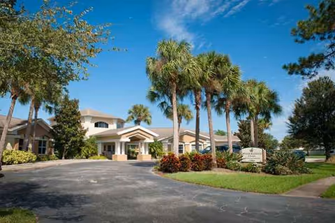 Exterior view of Best Care Senior Living at Brandon showing entrance, driveway, and palm trees.