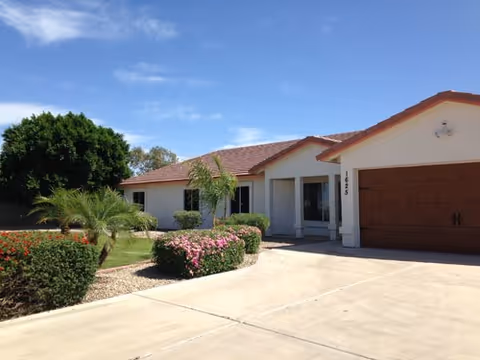 Front view of Mayfair Eden Homes, a single-story senior housing facility with landscaped driveway.