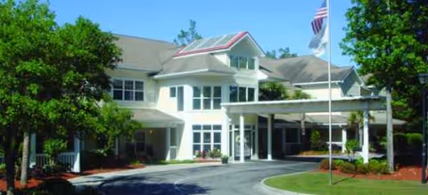 Front view of Brookdale West Ashley senior living facility with a covered entrance and flagpole.