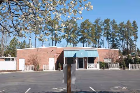 Front view of Carver Rehabilitation & Living Center with blue awning and parking