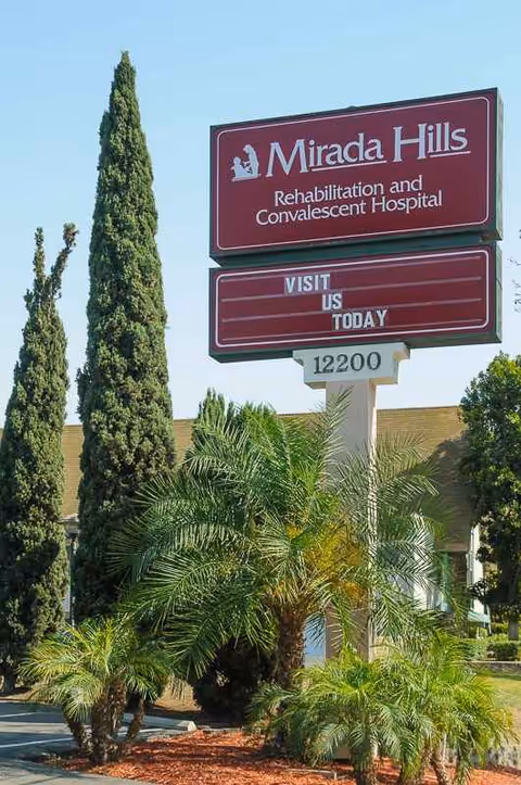 Sign for Mirada Hills Rehabilitation and Convalescent Hospital with palm trees.