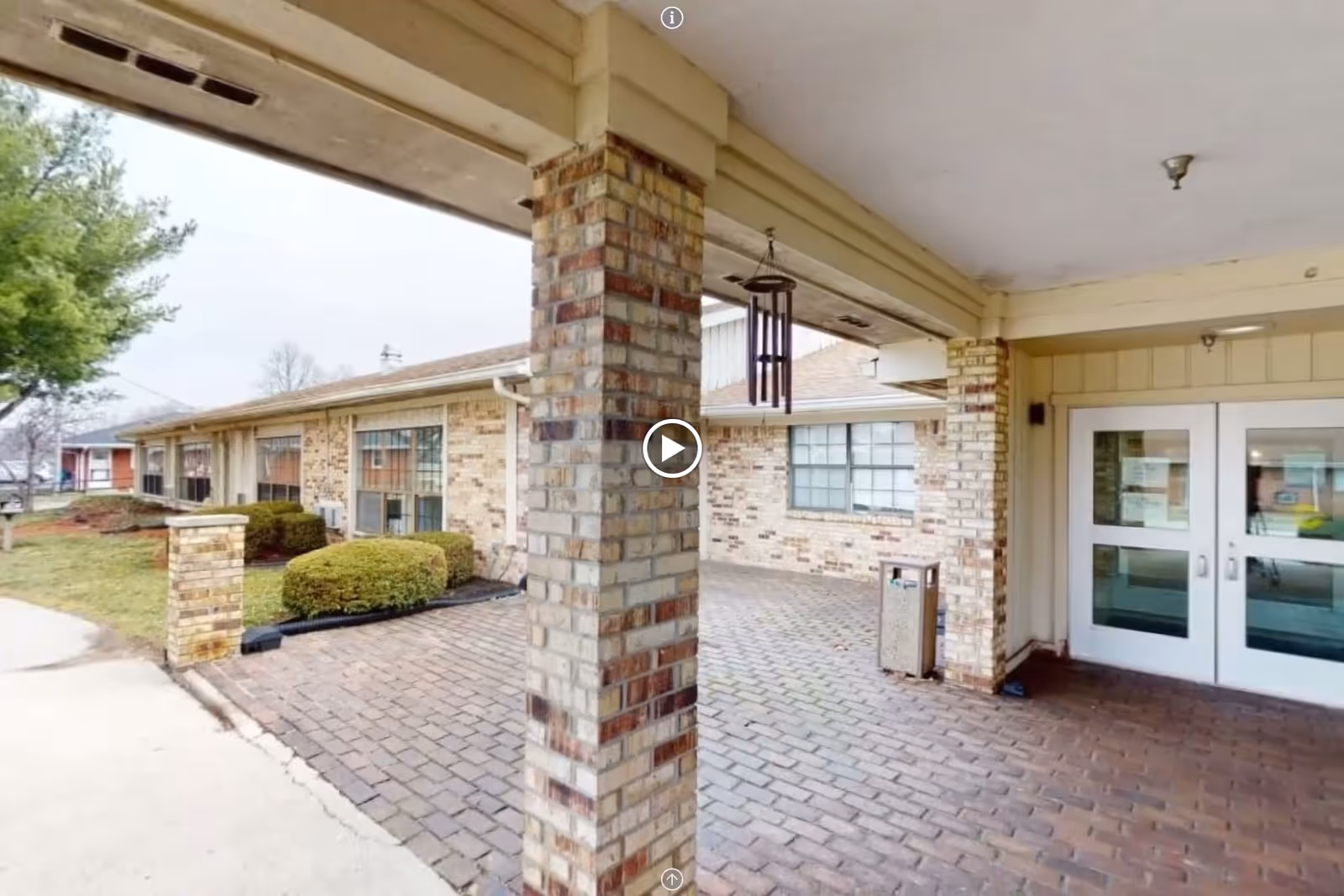 Entrance view of Majestic Care of Connersville with brick pathway and landscaping.
