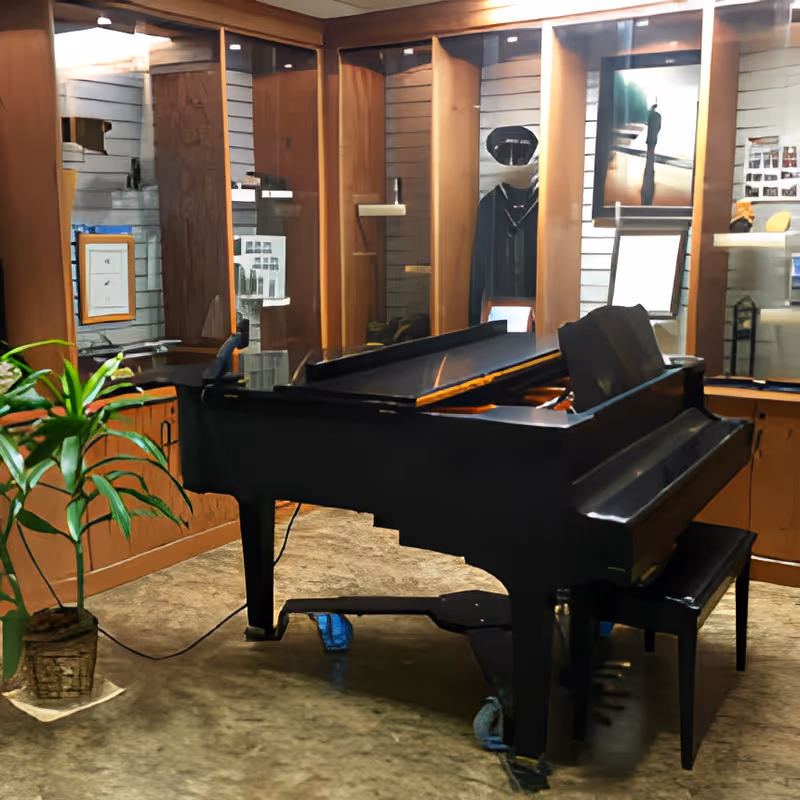 A black grand piano sits in a wood-paneled interior lobby area with display cabinets and a potted plant.