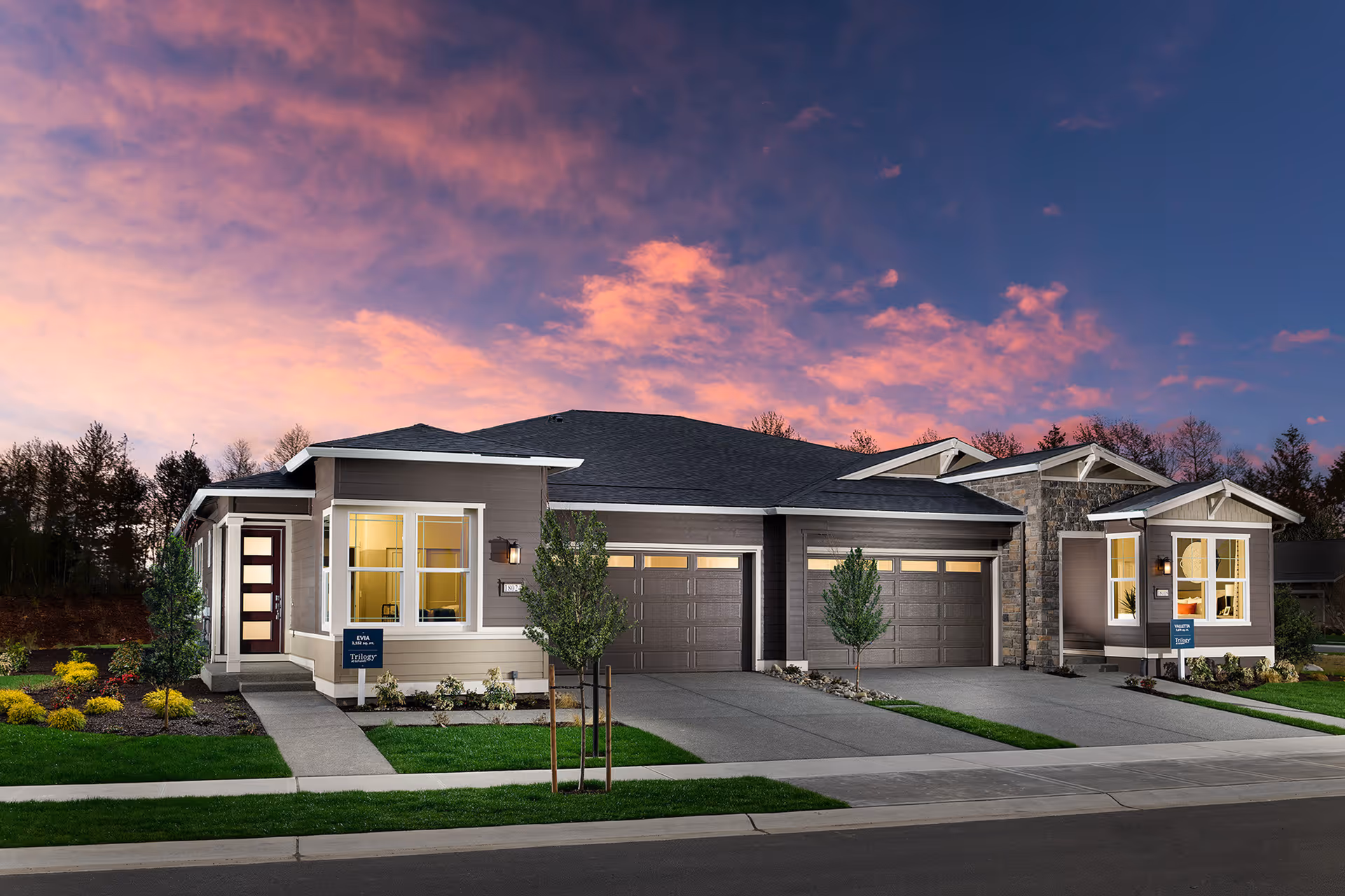 Exterior view of a modern single-story residential building with a three-car garage, well-maintained landscaping, and a colorful sunset sky in the background.