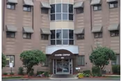 Front exterior view of the Chapin Center building with a glass entrance, awning labeled 'CHAPIN CENTER', and surrounding landscaping including bushes and small trees.