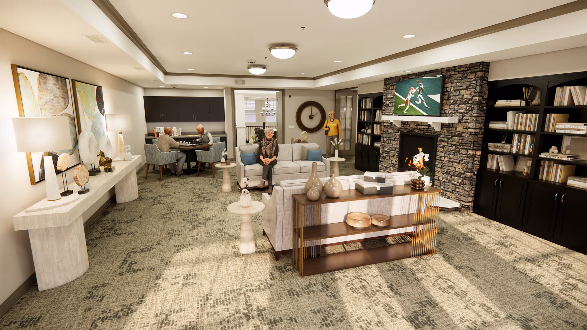 A spacious senior living common area with comfortable seating including sofas and armchairs. Three seniors are visible: one sitting on a sofa, two playing chess at a round table, and one standing near a wall clock. The room features a stone fireplace with a TV mounted above it, built-in bookshelves filled with books, decorative vases on a console table, and soft lighting from lamps and ceiling fixtures.