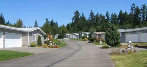 Exterior view of Lakes at Gig Harbor cottages along a curved road.