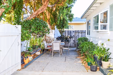 Outdoor patio at the Golden Age Senior Care Center with table, chairs, and potted plants.