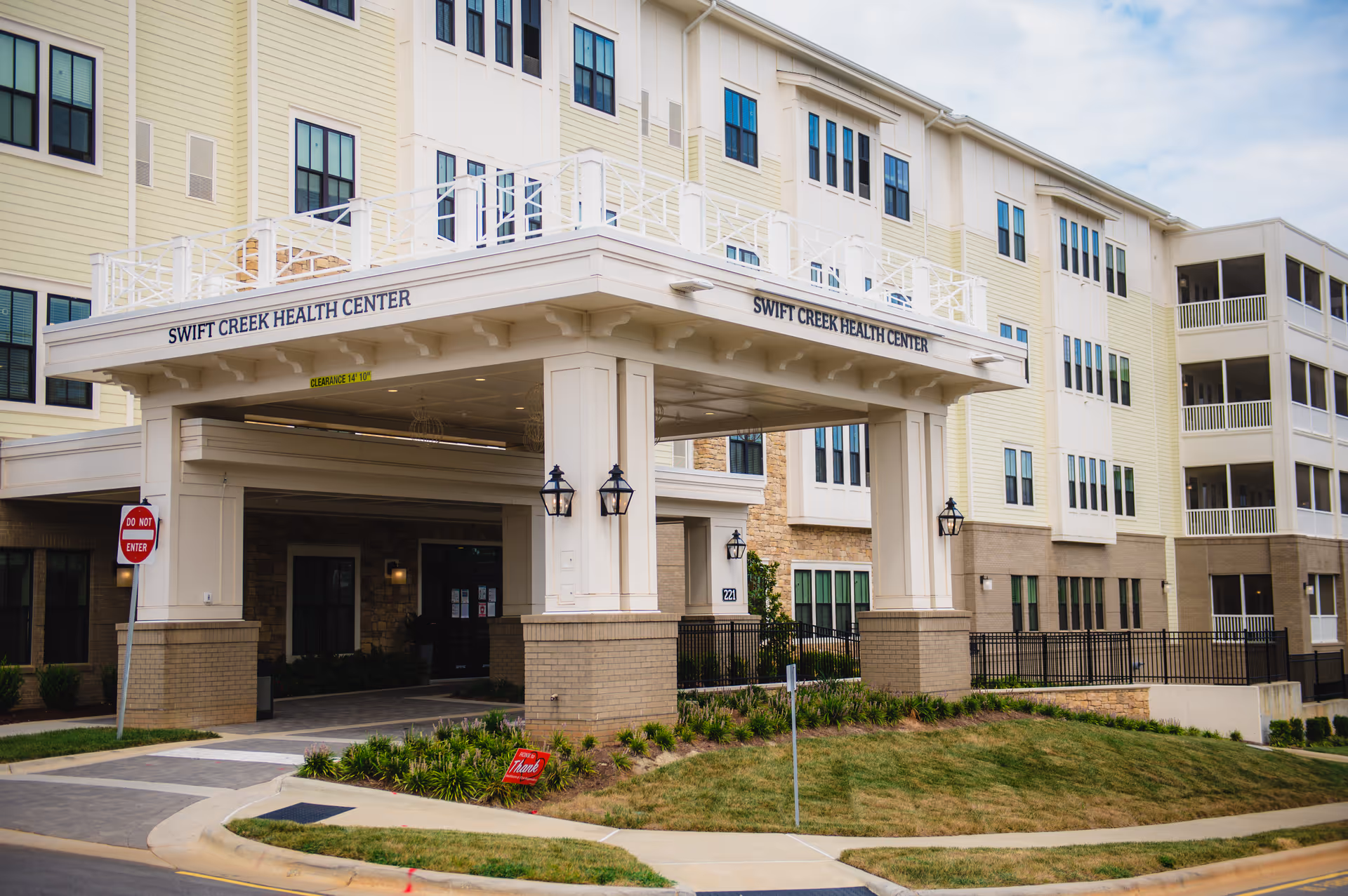 Front entrance canopy reading "Swift Creek Health Center" at a multi-story beige and white senior living building.