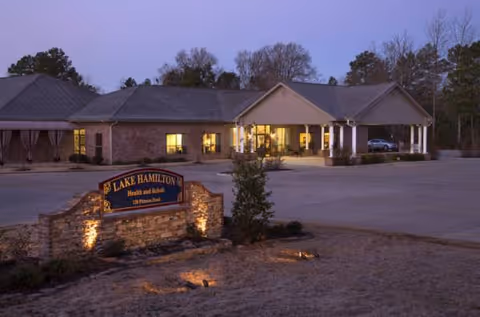 Evening exterior of Lake Hamilton Health and Rehab, showing the front entrance and signage.