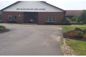 Front entrance of Mid-Valley Health Care Center, a single-story brick building with a driveway and landscaped beds.
