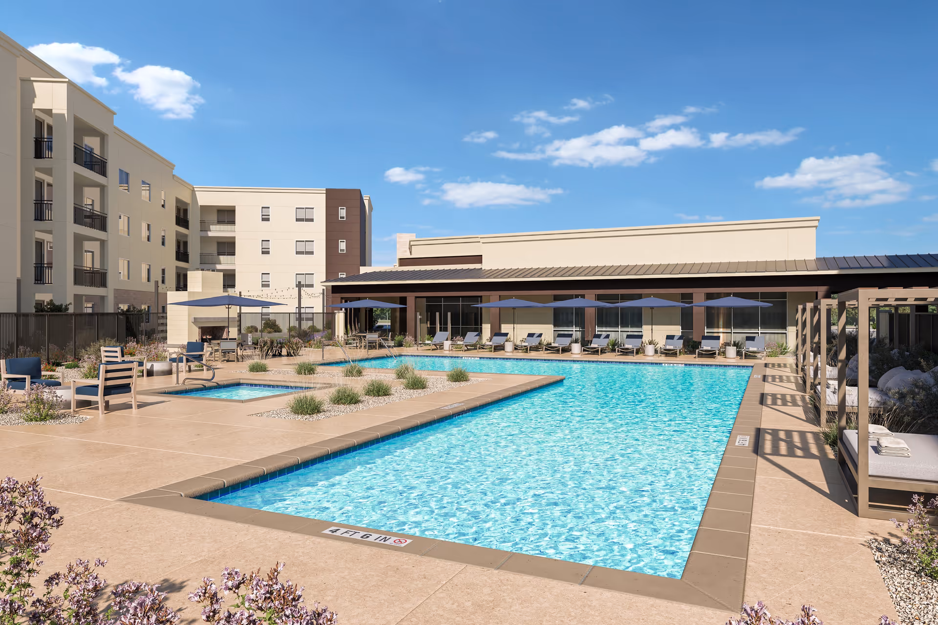 Outdoor swimming pool area at Album Union Village with lounge chairs, umbrellas, a small hot tub, and a building in the background under a blue sky with scattered clouds.