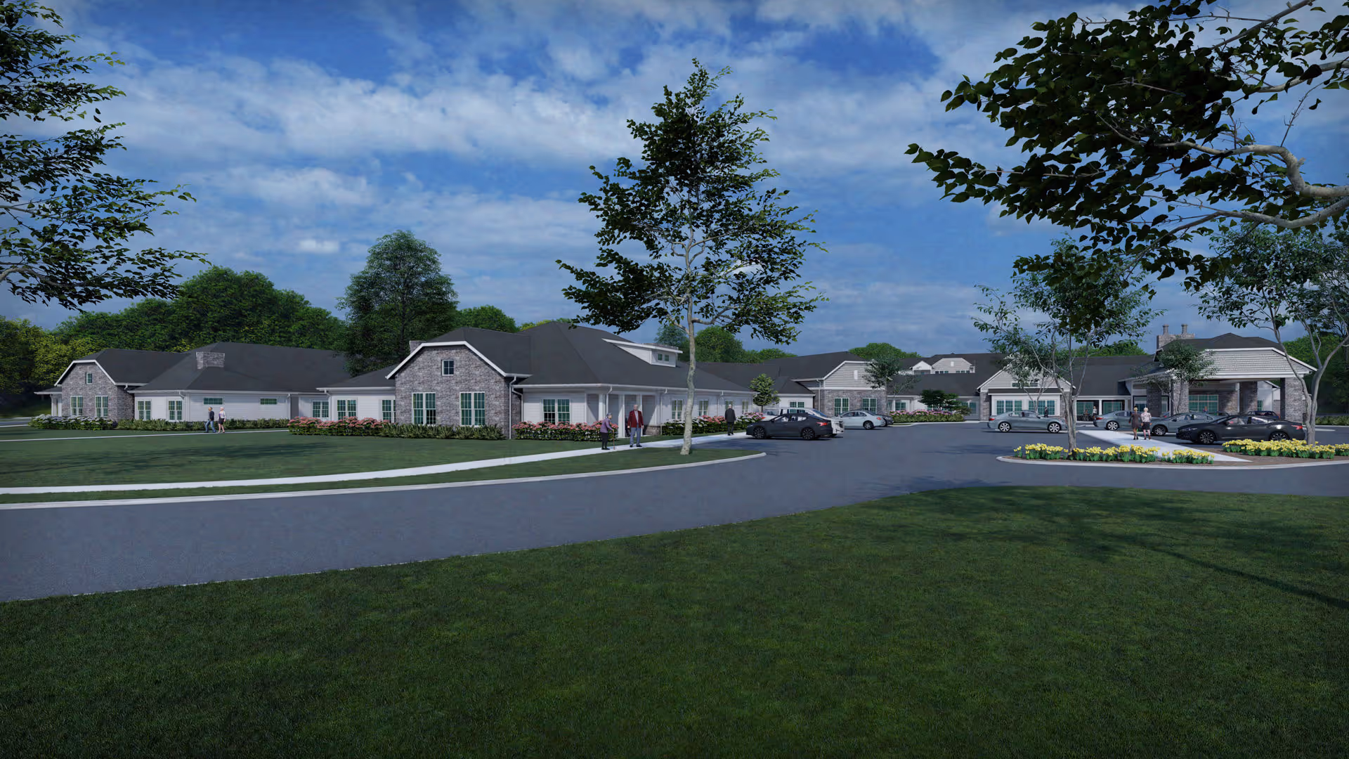 Exterior view of a single-story senior living facility with multiple connected buildings, surrounded by green lawns, trees, and a paved driveway with parked cars under a partly cloudy sky.