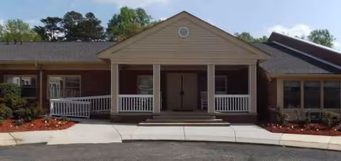 Front view of a single-story senior living center with a covered porch and steps.