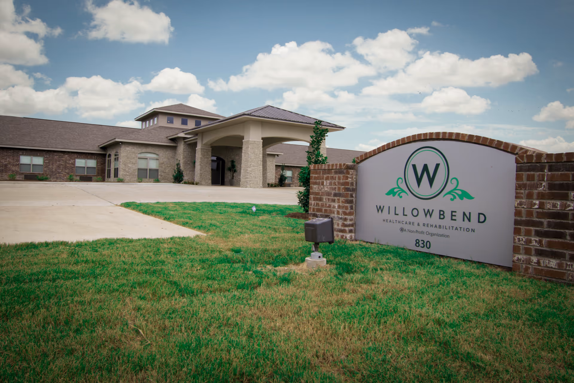 Exterior view of Willowbend Healthcare and Rehabilitation facility with a sign in front.