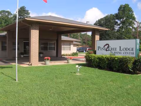 Pine Tree Lodge Nursing Center exterior with entrance, sign, and well-kept lawn.