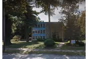 Front view of Bethesda Court PCH building with trees and a grassy lawn.