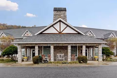 Front view of Laurelhurst and Laurelwoods facility with stone facade and porch seating.