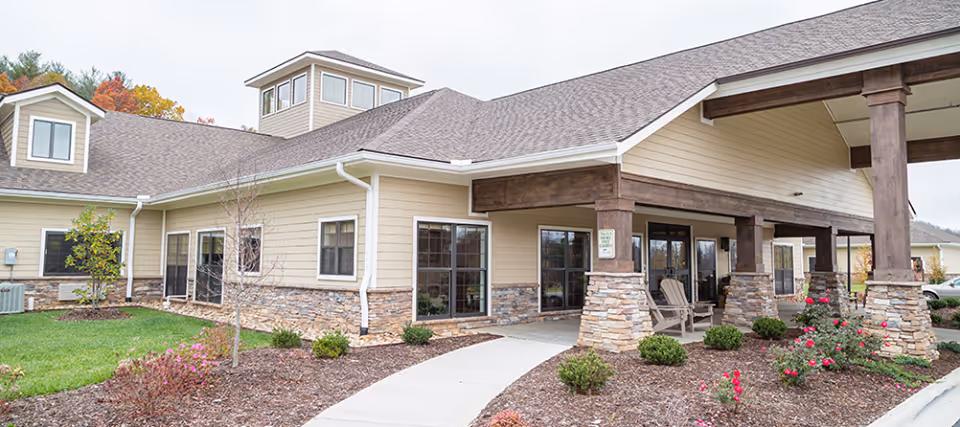 Exterior view of The Lodge at Mills River Health and Rehabilitation, showing an entrance and landscaping.