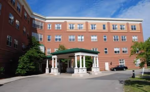 Wingate Residences on Blackstone Boulevard exterior with brick facade, white columns, green canopy, and driveway.