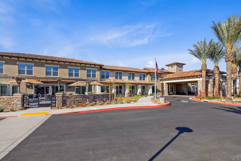 Exterior view of Oakmont of Westpark showing a two-story building and palm trees.