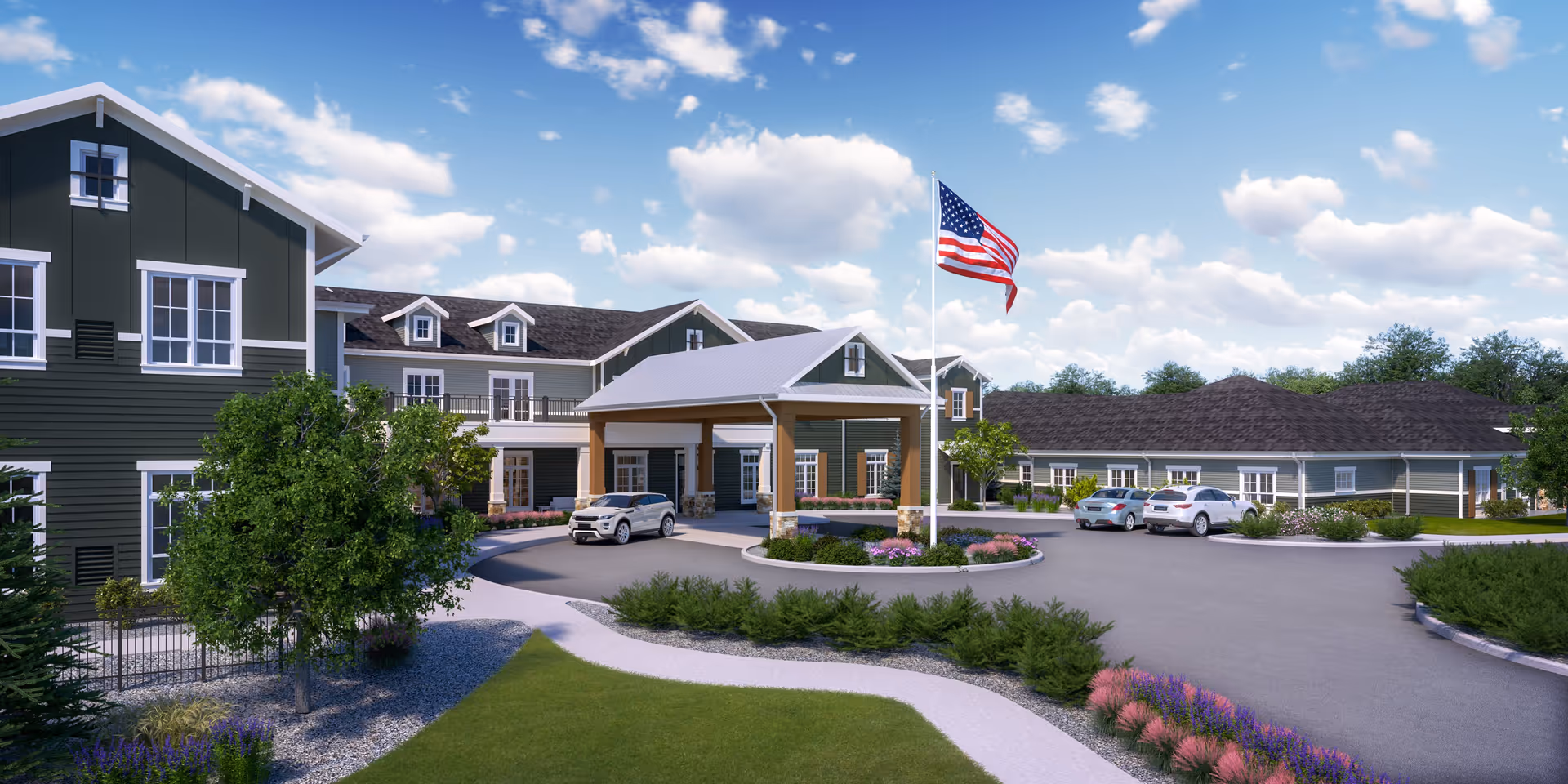 Exterior view of a senior living facility with a covered entrance, several parked cars, landscaped gardens, and an American flag on a flagpole under a partly cloudy sky.