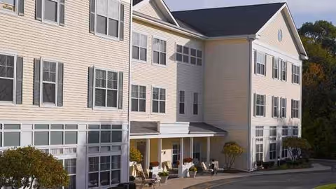 The exterior view of Atria Lincoln Place shows a multi-story senior living building with front entrance.