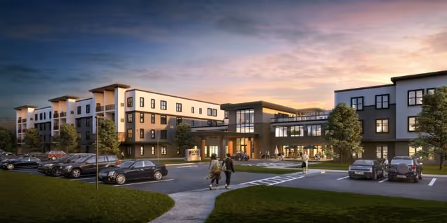 Exterior view of Rose Senior Living Farmington Hills campus at dusk with parking lot and entrance.