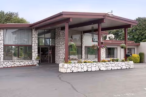 Exterior view of Riverside Nursing & Rehab Center with stone facade and covered entrance.