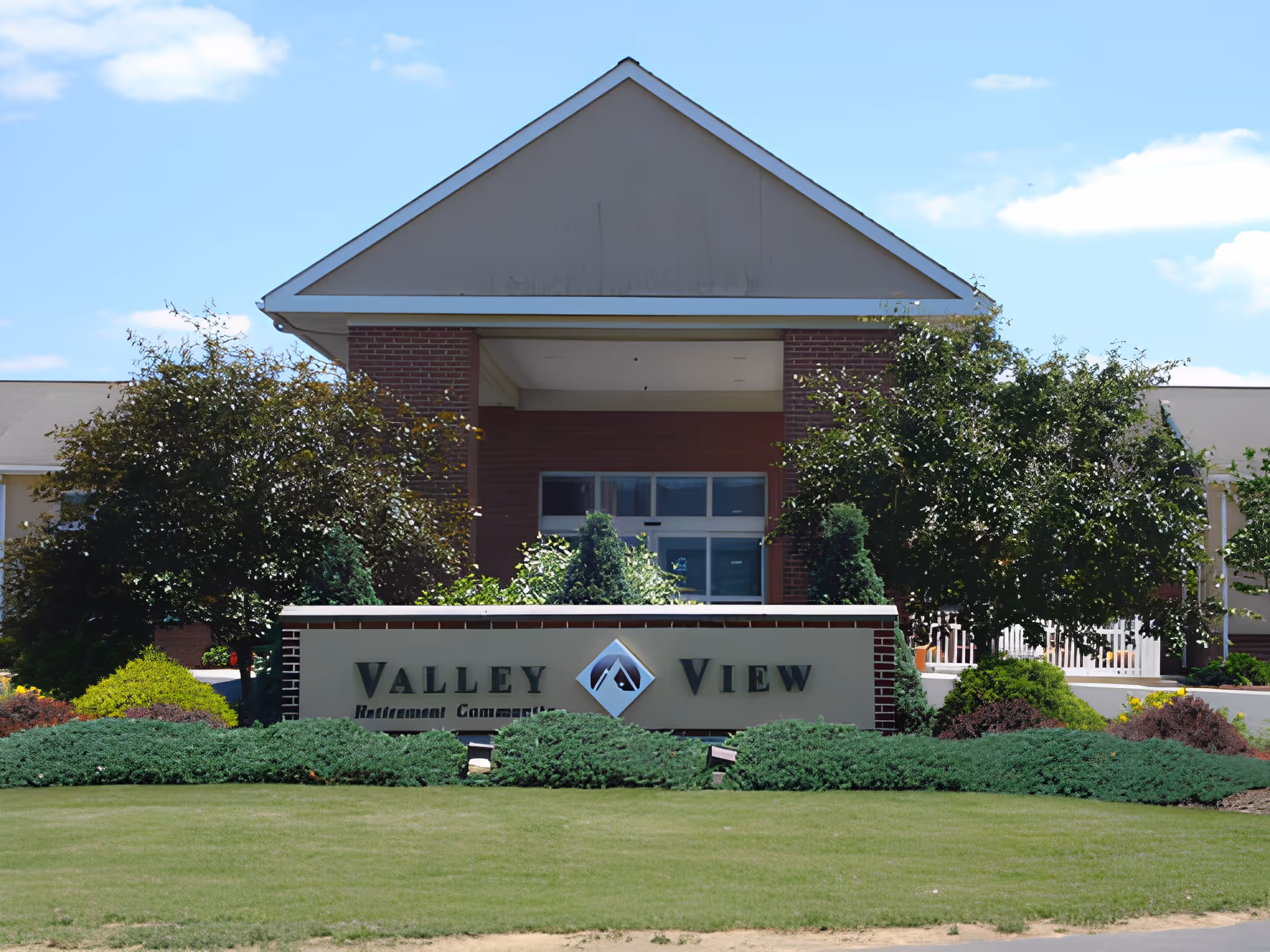 Entrance of Valley View Retirement Community showing the building facade, a front sign, and landscaped lawn.