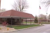 Exterior view of Golden LivingCenter - Sycamore Village with a covered entrance and flag