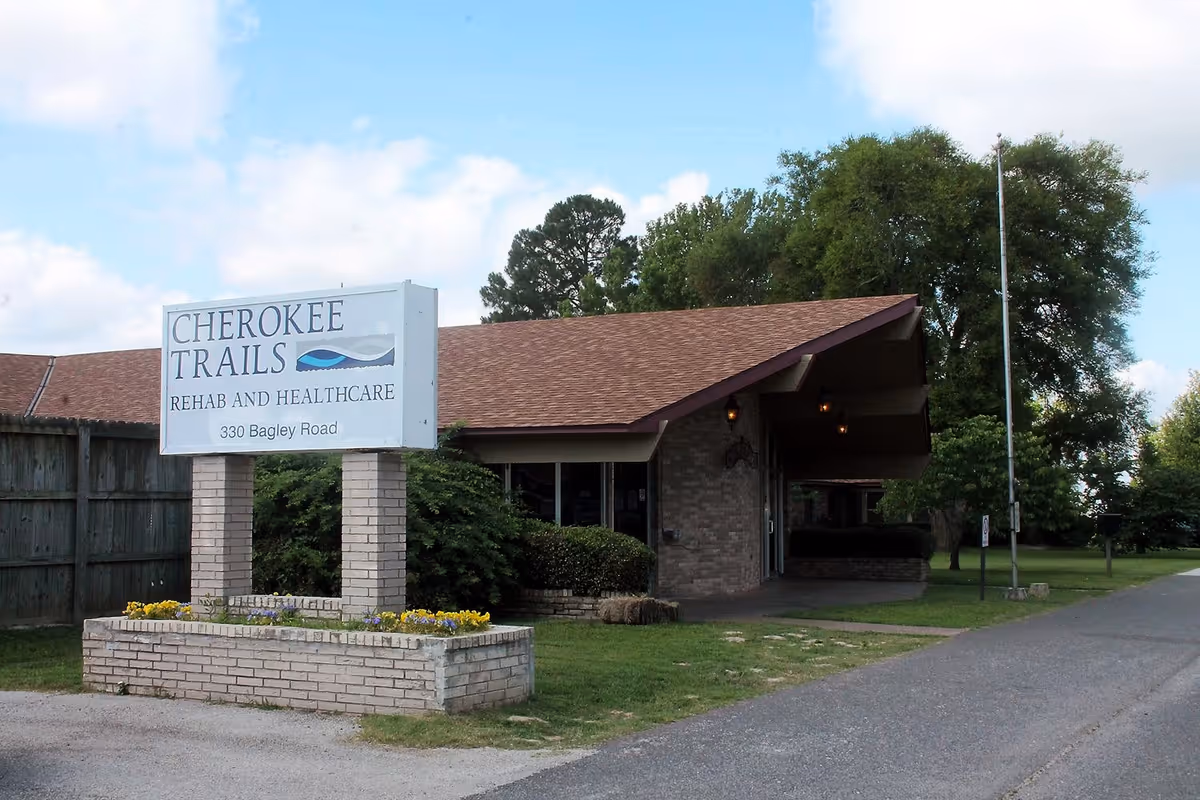 Front exterior of Cherokee Trails Rehab and Healthcare building showing the entrance and a large sign.