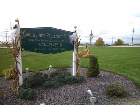 Lawn area with Country Aire Retirement Estate sign and surrounding landscaped bed.