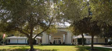 Front view of Brookdale Pointe West building with columns and trees.