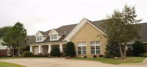 Front exterior view of Dorset Place Assisted Living with entrance and shrubs.