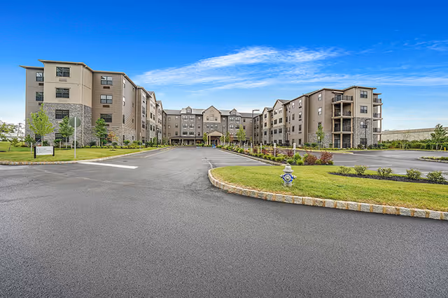Exterior view of The Pinnacle at Plymouth Meeting senior living campus with a curved driveway