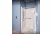 Blue-walled accessible bathroom featuring a shower stall with grab bars.