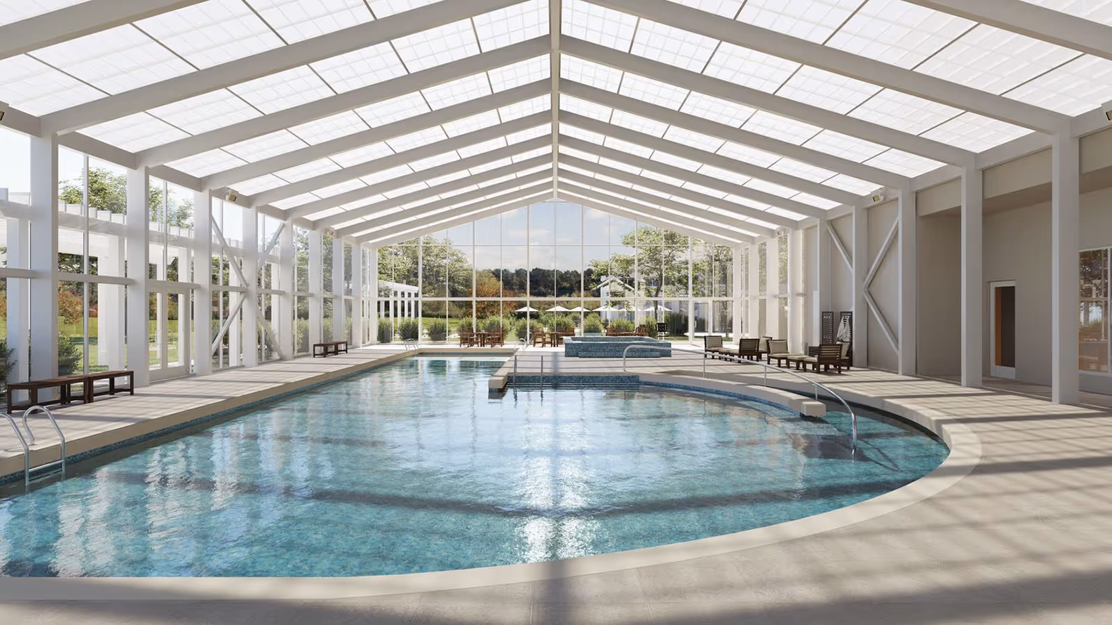 A spacious, skylit indoor swimming pool with lounge chairs and floor-to-ceiling windows overlooking landscaped grounds.