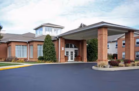 Exterior view of The Waterford at Fairfield entrance with brick columns and covered porte-cochere