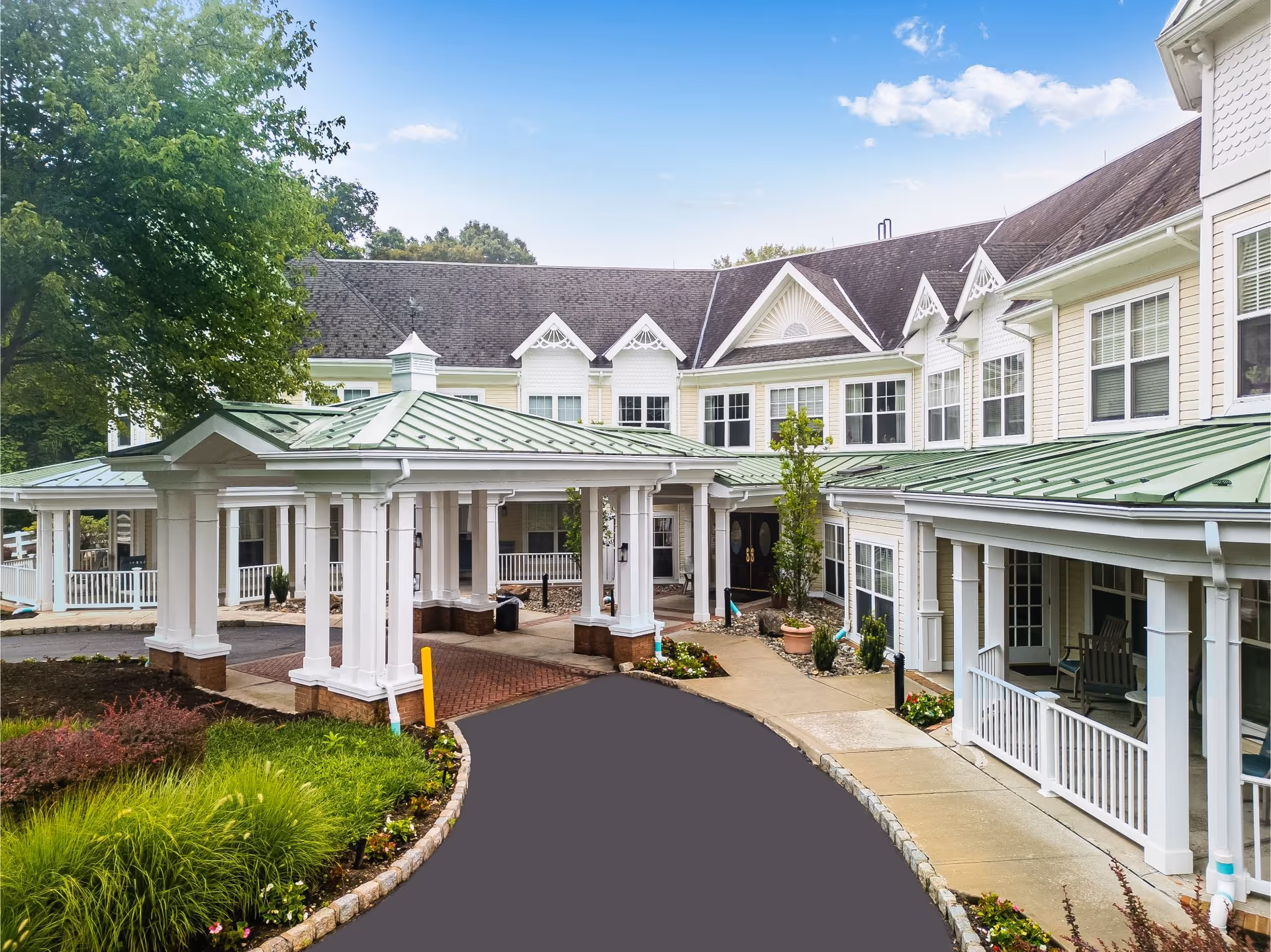 Sunrise of Old Tappan exterior featuring white columns, green roof, and covered entrance.