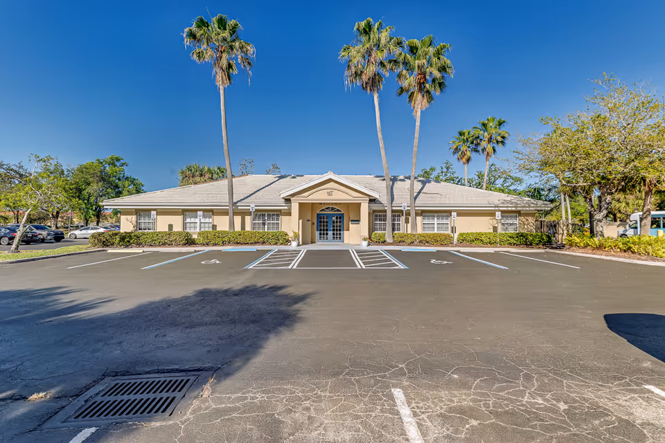 Healthpark Senior Living facility with a beige, single-story building, palm trees, and a paved parking lot.