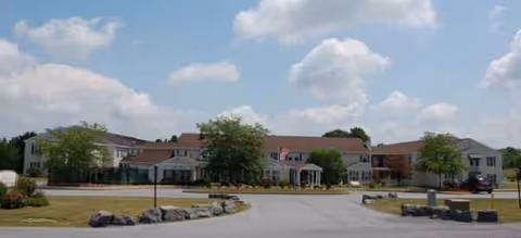Exterior view of Brookdale Clinton facility with an entrance, driveway, and surrounding landscaping.
